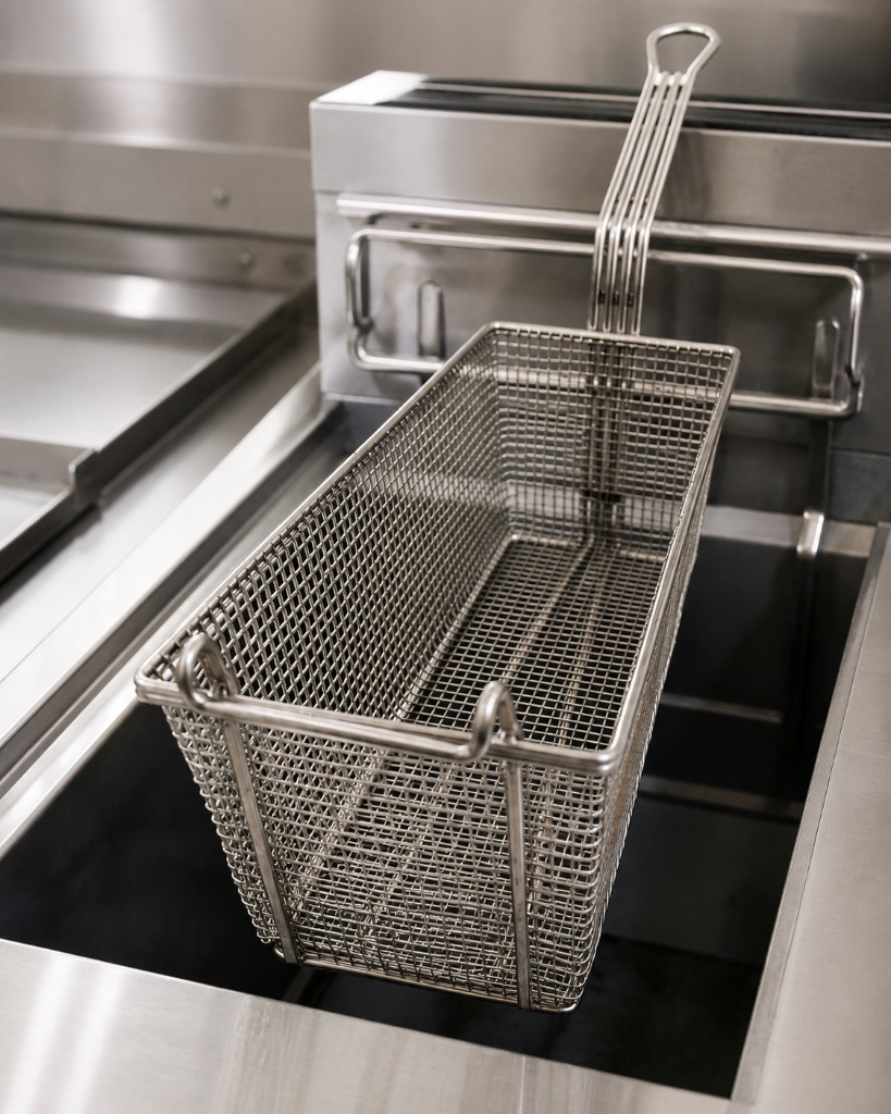 Commercial stainless fryer basket over fryer well